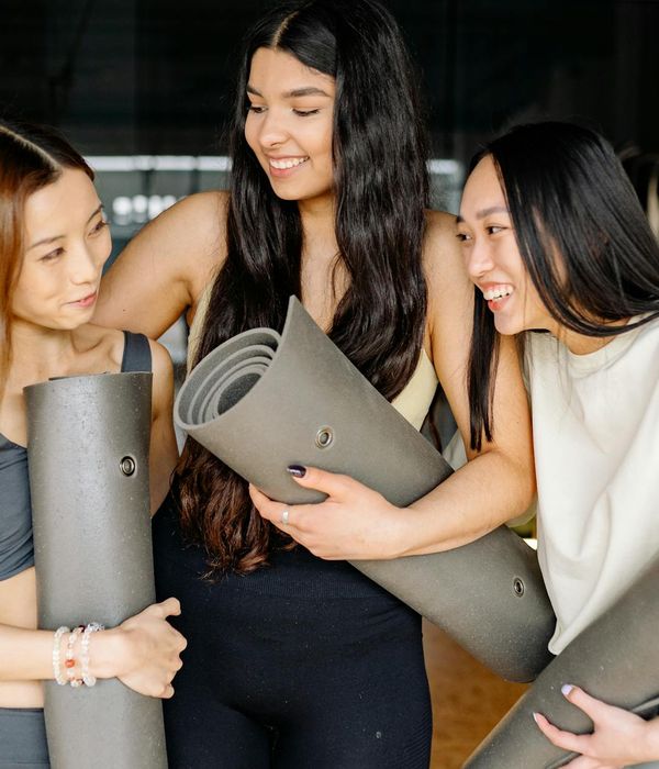 A group of pregnant women smiling together during a yoga class.